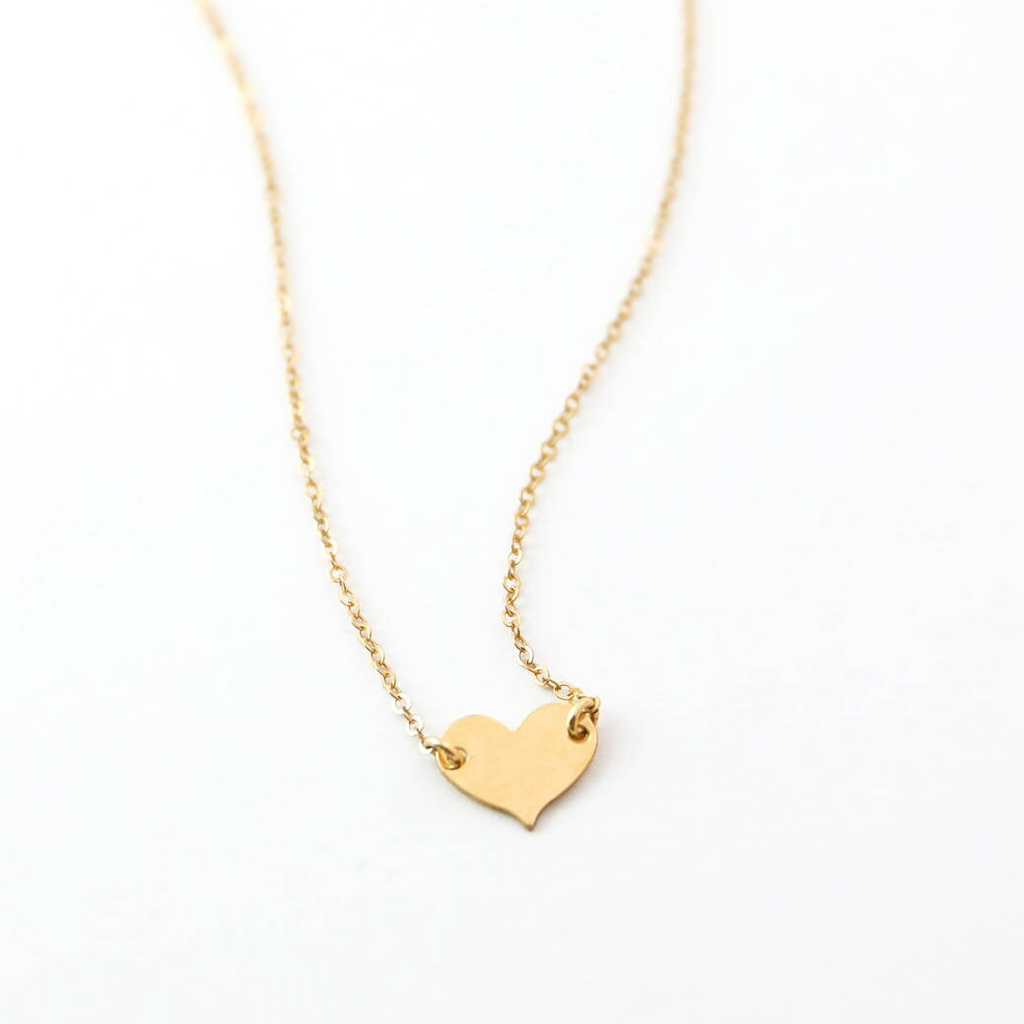 a gold heart necklace on a white background