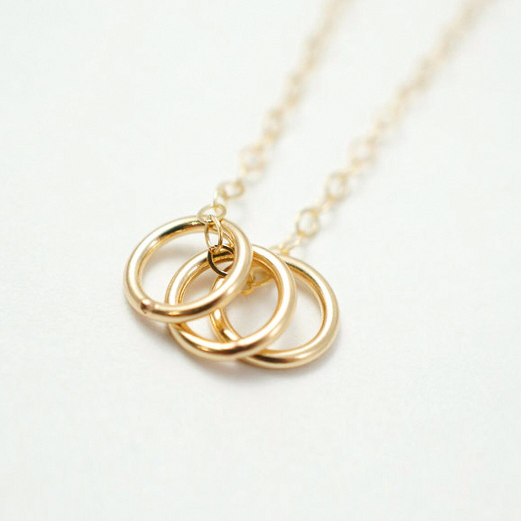 a gold necklace with three intertwined rings