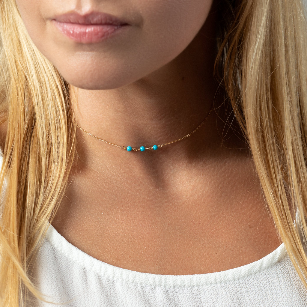 a close up of a woman wearing a necklace