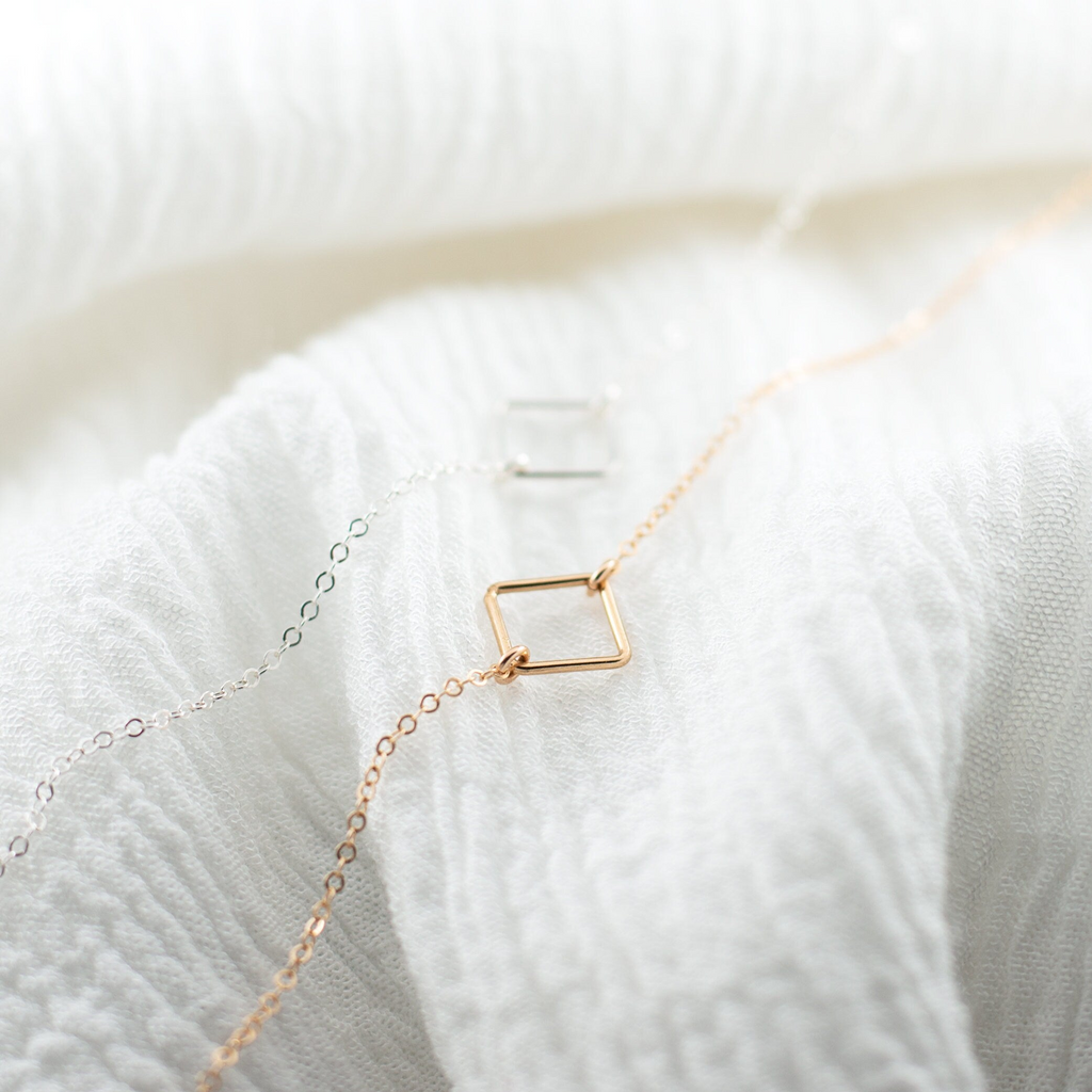 a white sweater with a gold necklace on it