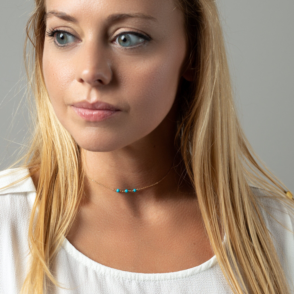 a woman with long blonde hair wearing a necklace
