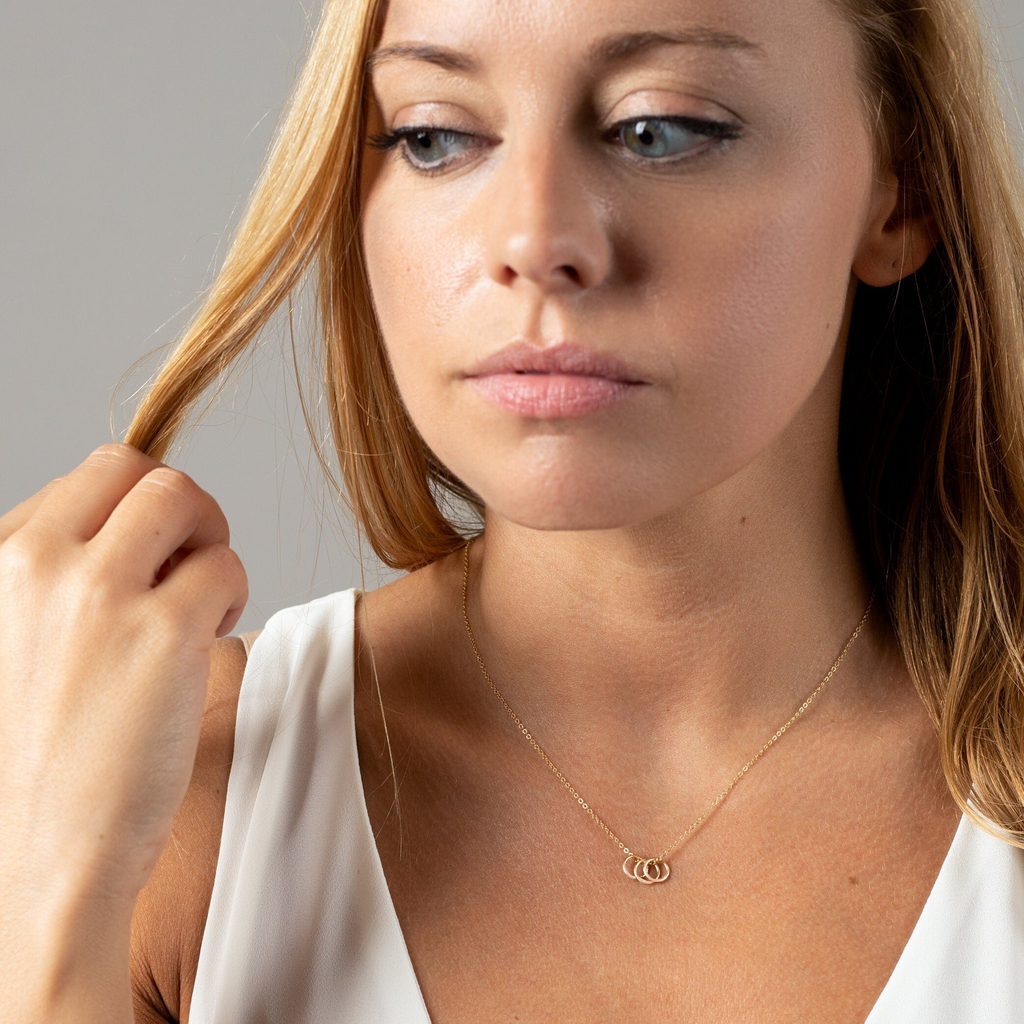 a woman wearing a necklace and a white shirt