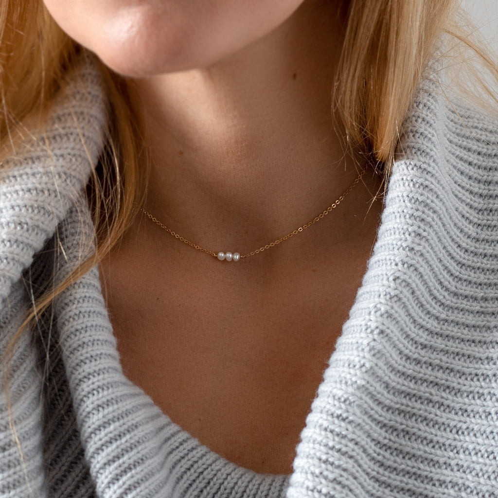 a close up of a woman wearing a necklace