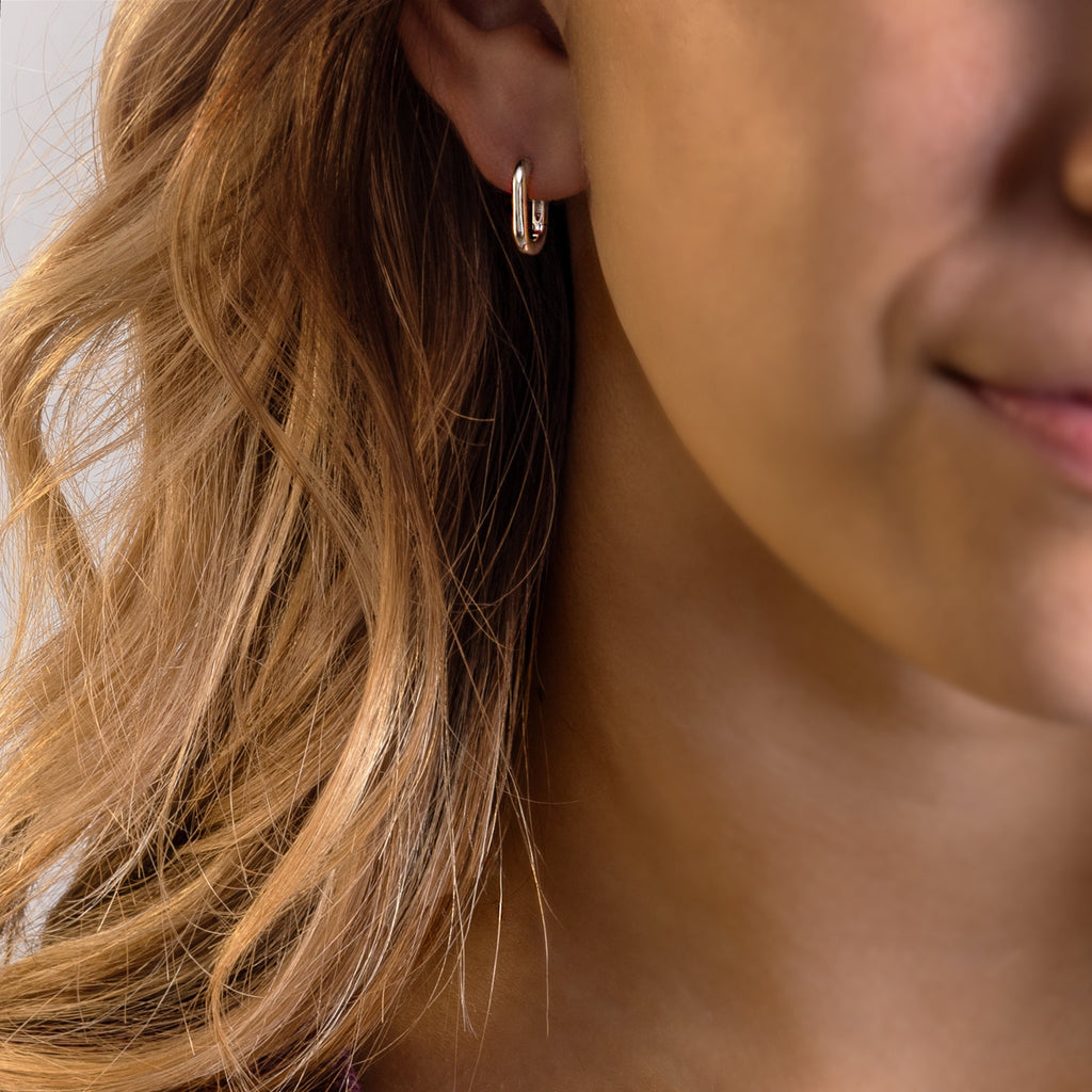 a close up of a person wearing a pair of earrings