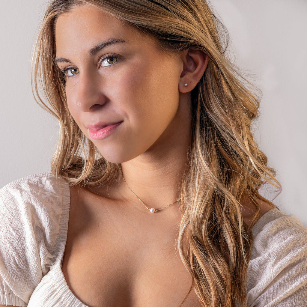 a close up of a woman wearing a necklace