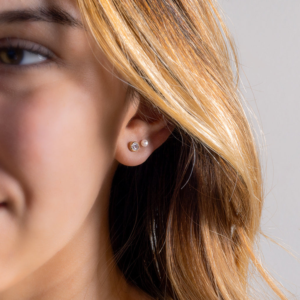 a close up of a person wearing a pair of earrings