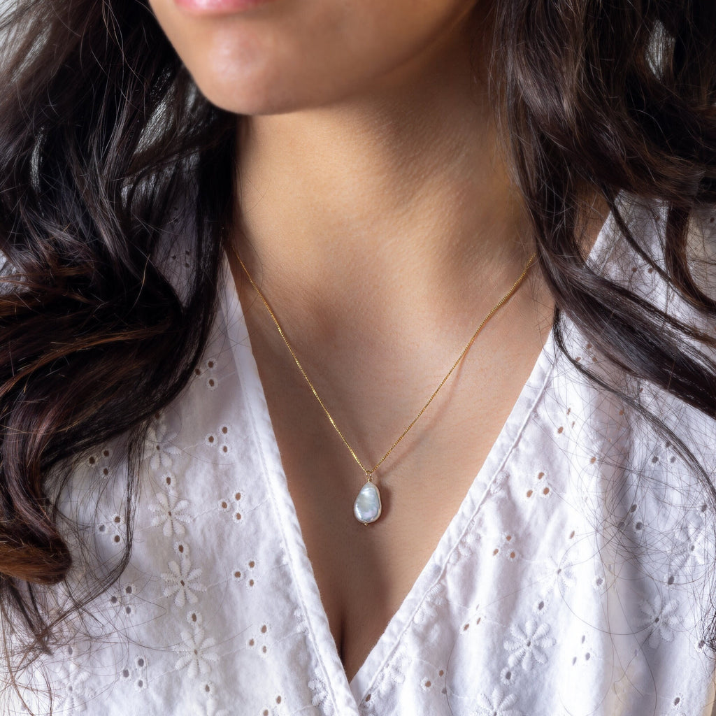 a close up of a woman wearing a necklace