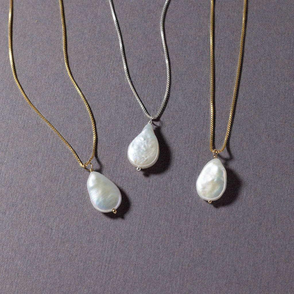 a group of three necklaces sitting on top of a table