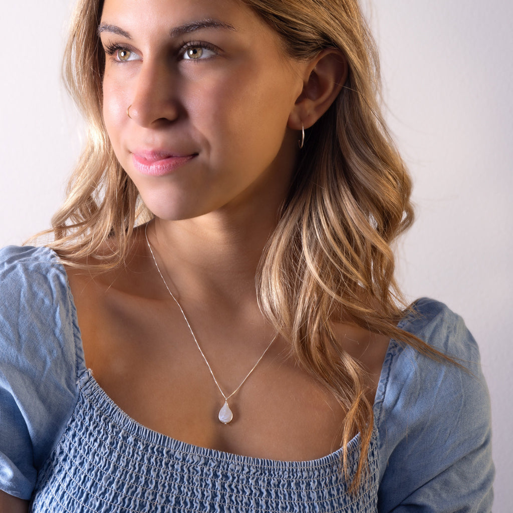 a woman in a blue top is smiling for the camera