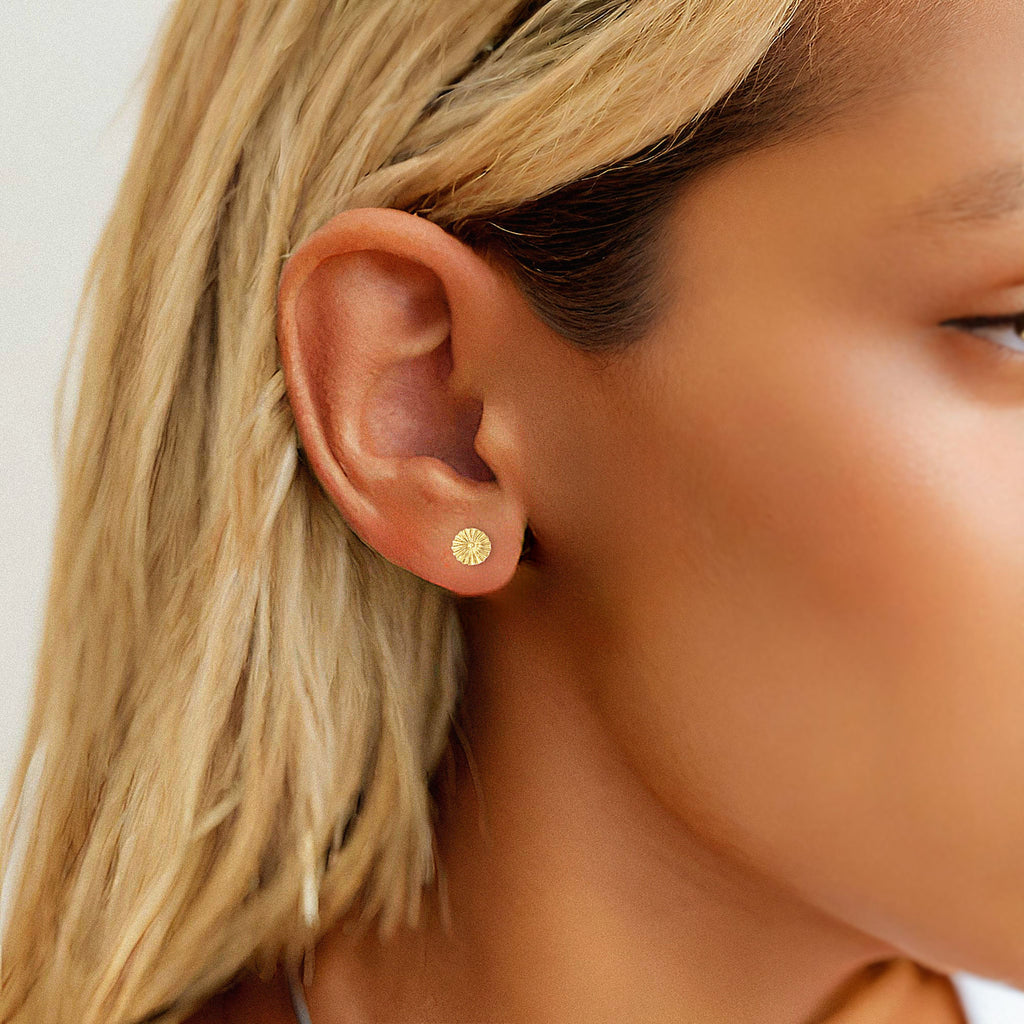 a close up of a person wearing a pair of earrings