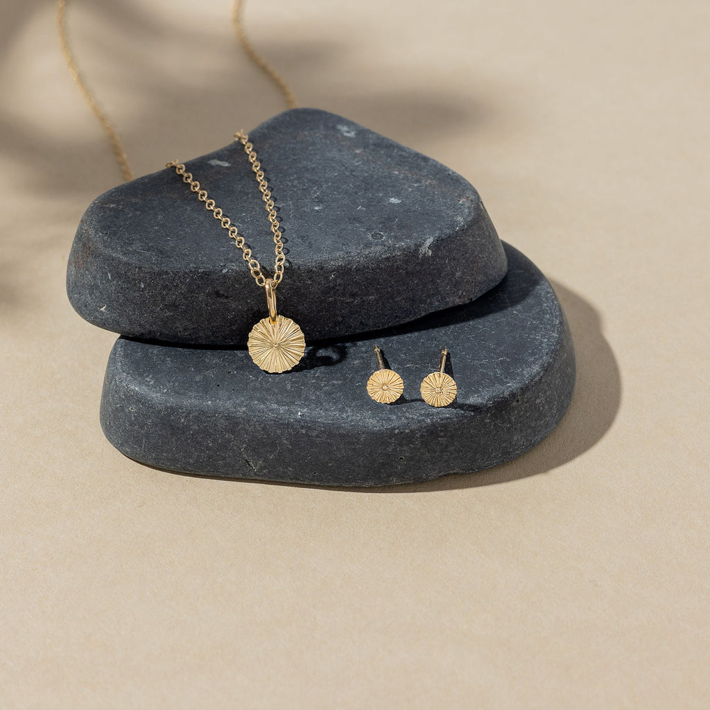 a pair of earrings sitting on top of a rock