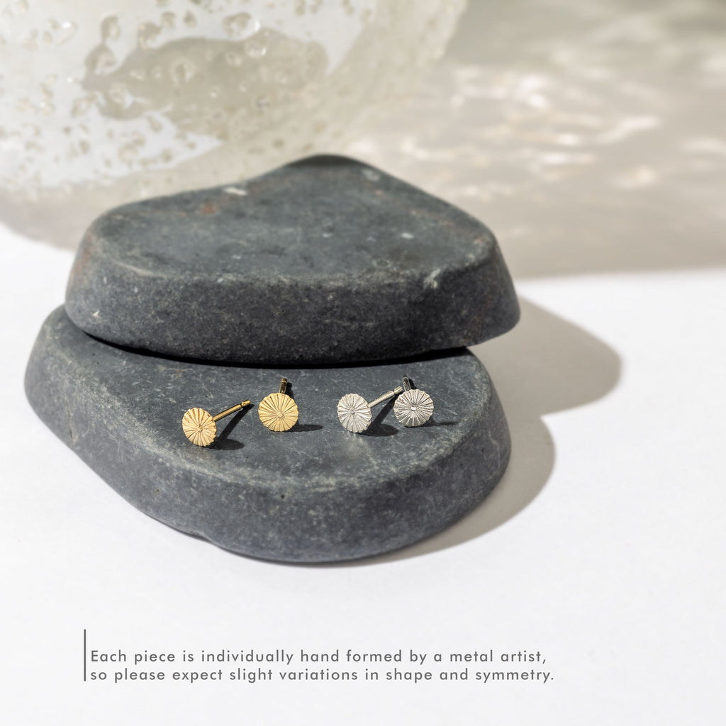 a pair of earrings sitting on top of a rock