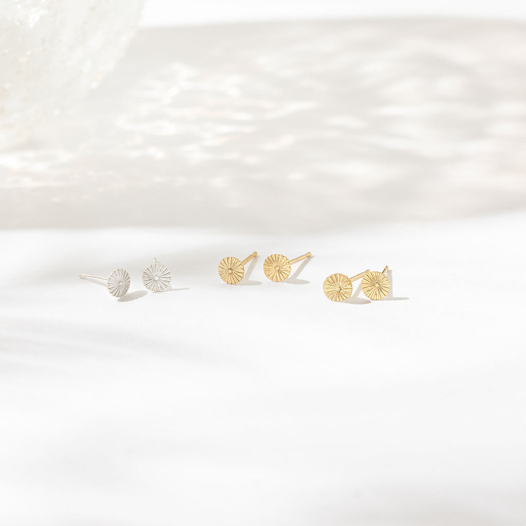 a pair of earrings sitting on top of a white surface