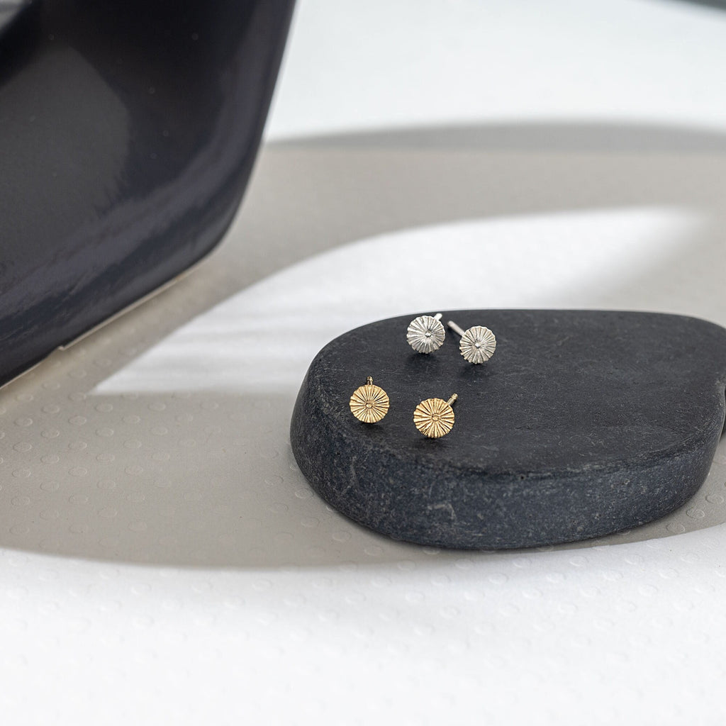a pair of earrings sitting on top of a rock