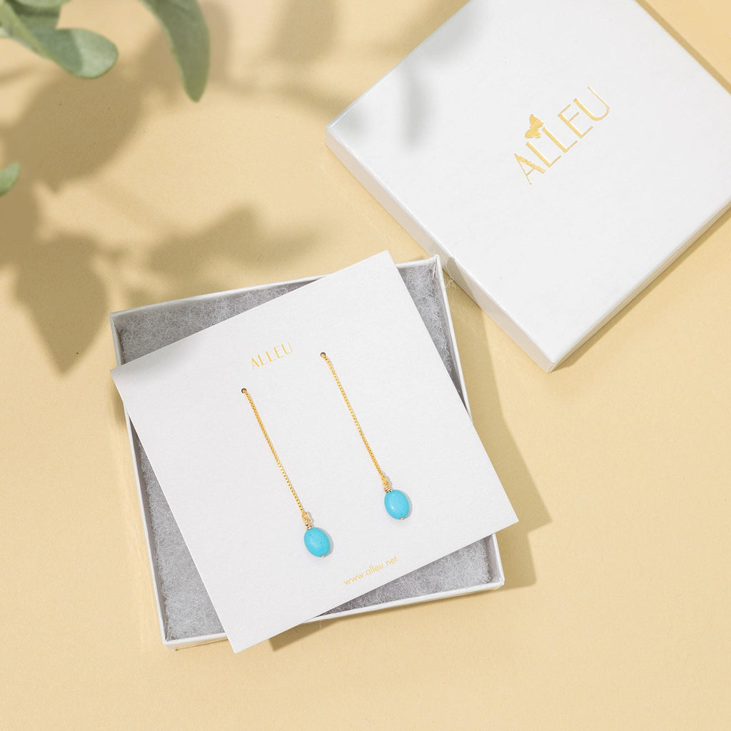 a pair of earrings sitting on top of a box