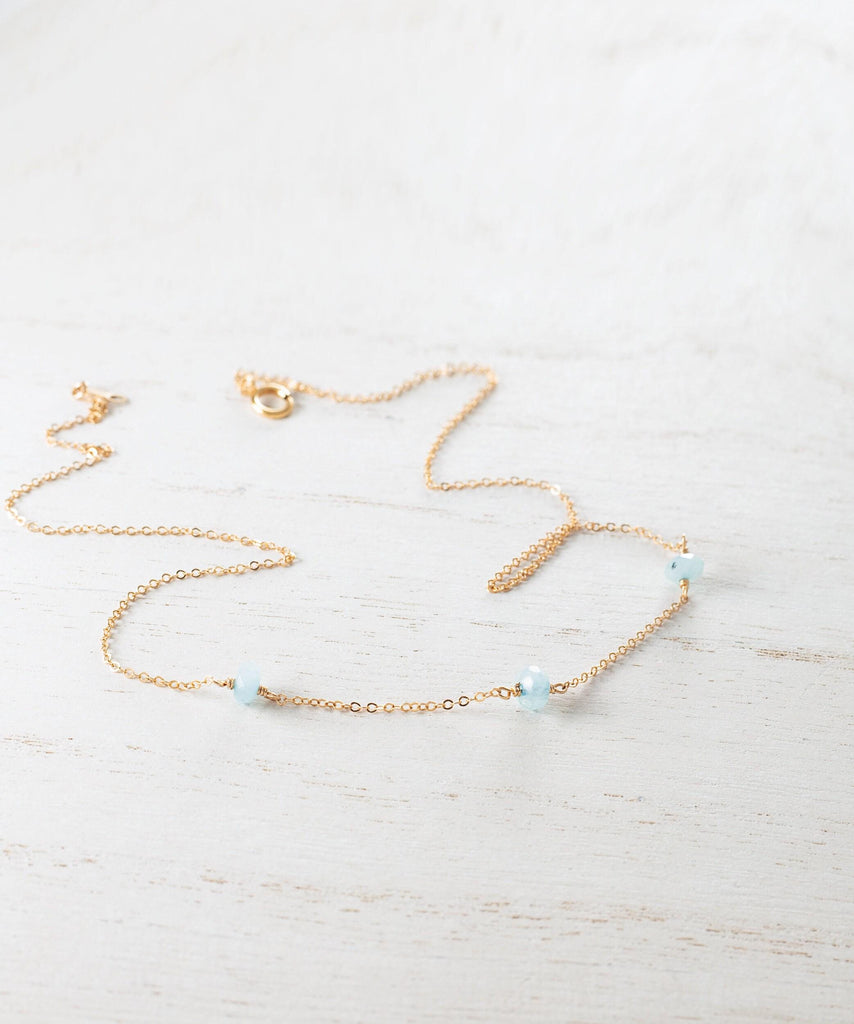 a gold necklace with blue beads and a star on it