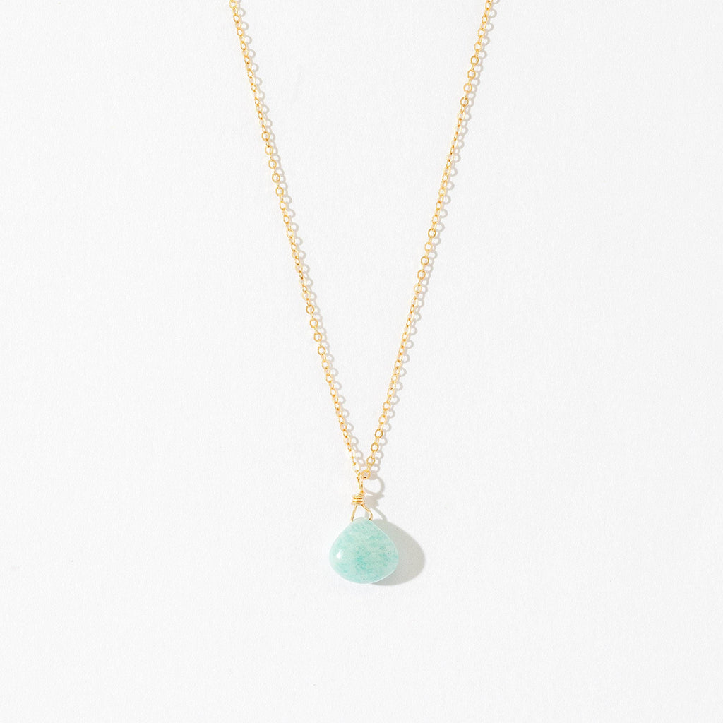 a gold necklace with a blue stone on it