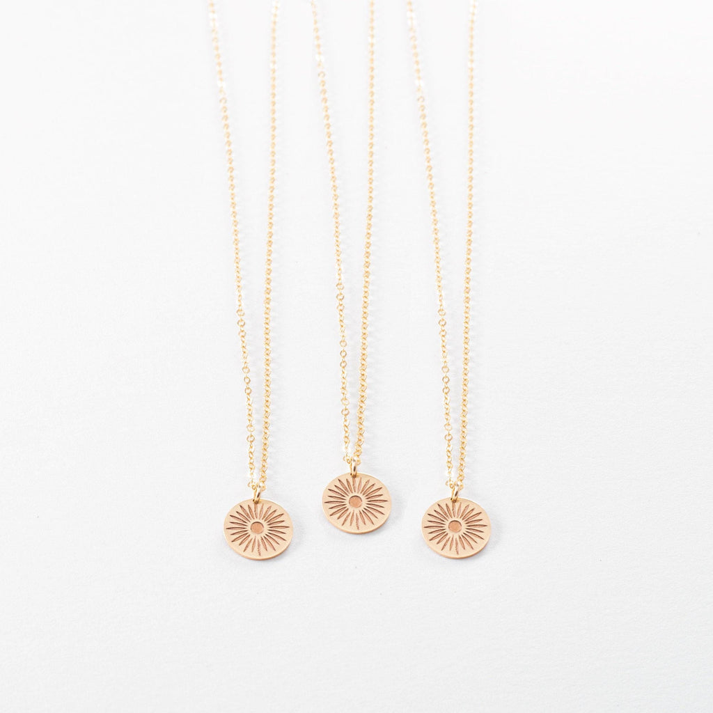 three gold necklaces on a white background