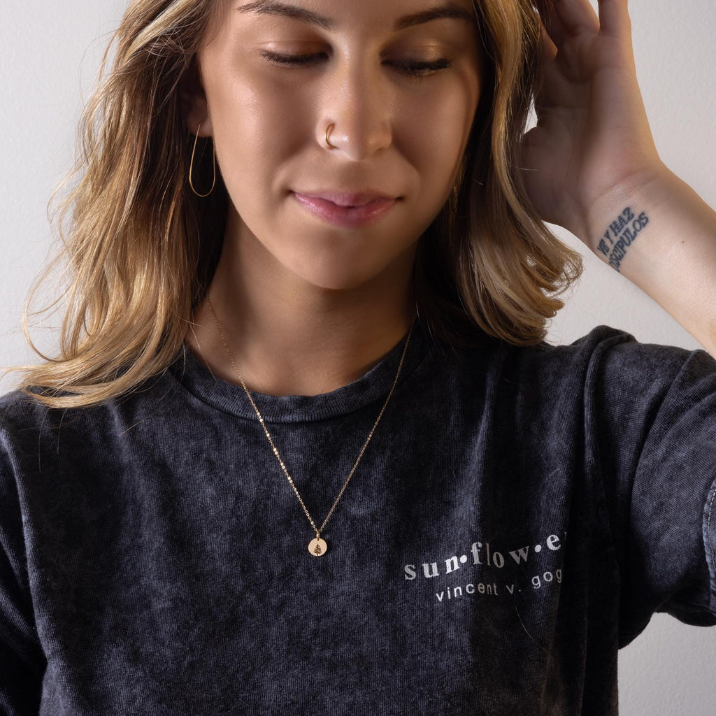 a woman wearing a black shirt and a gold necklace