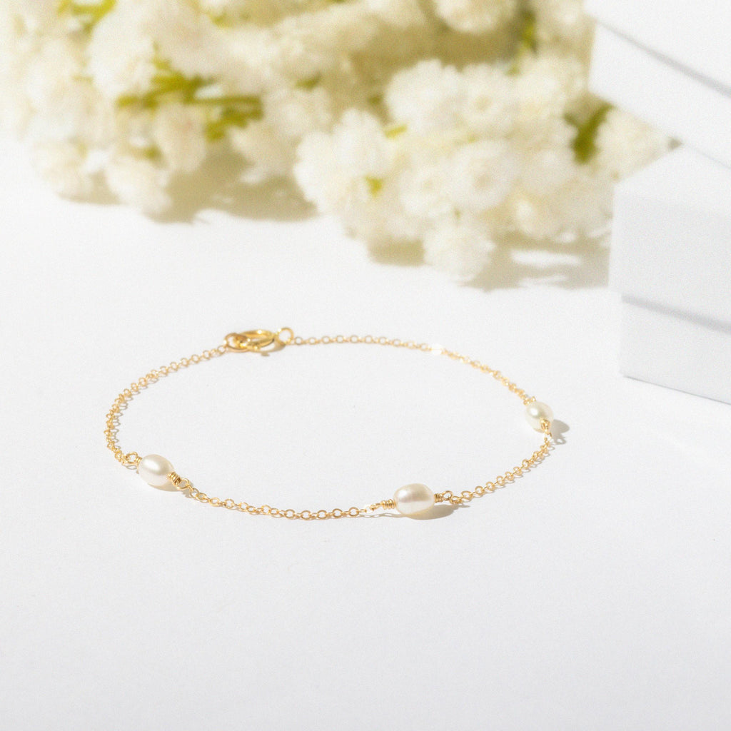 a bracelet with pearls on a white surface