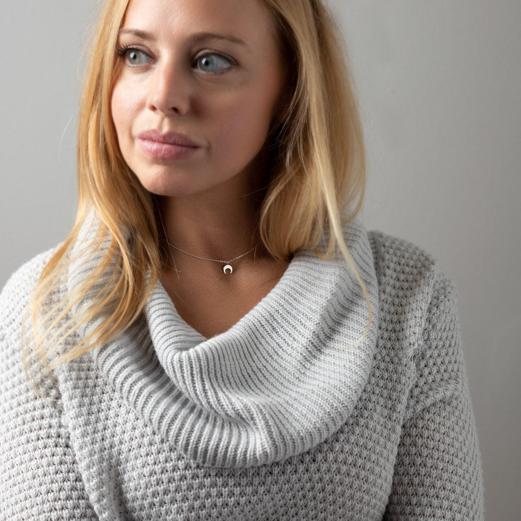 a woman in a sweater is posing for a picture