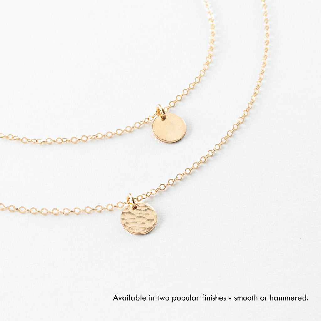 a gold necklace with two discs attached to it