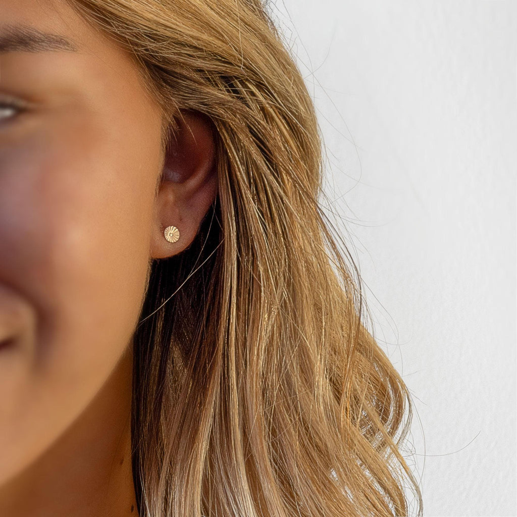 a close up of a person wearing a pair of earrings