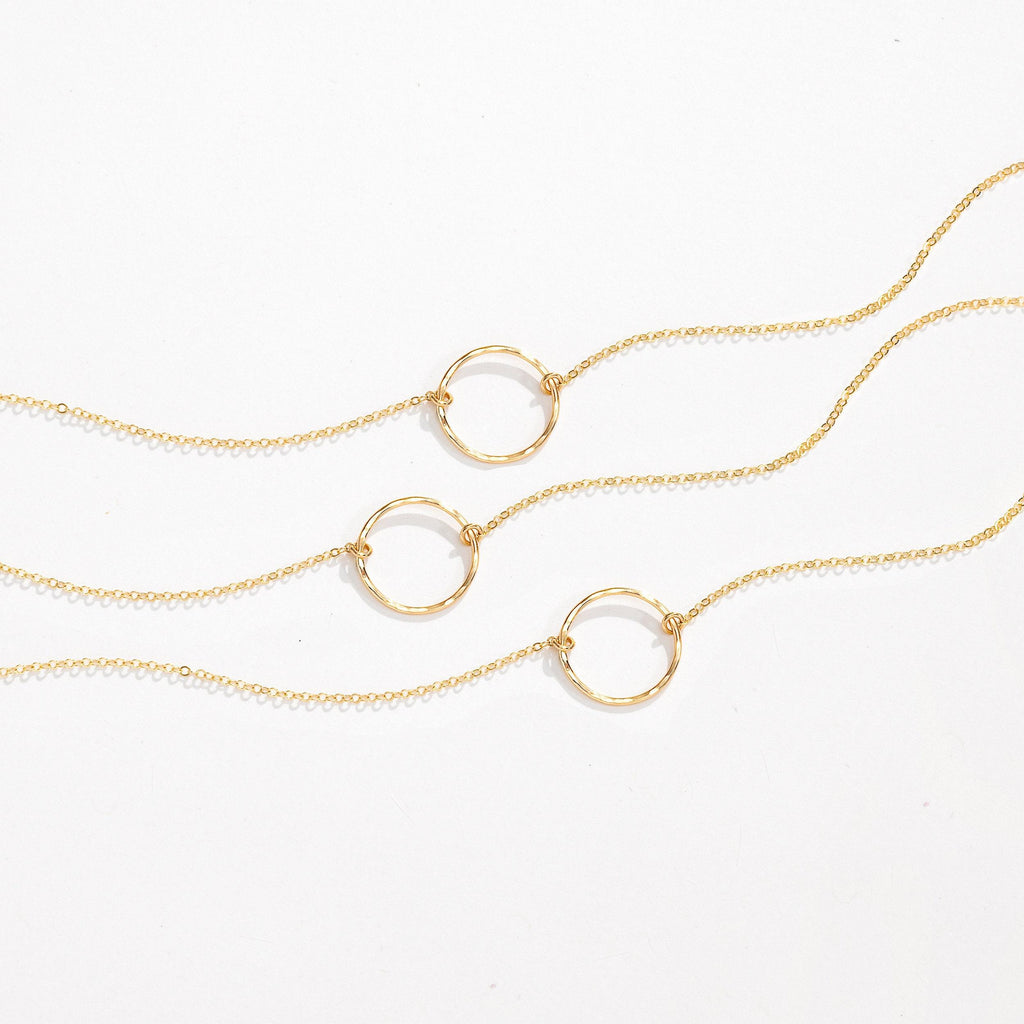 a gold necklace with three circles hanging from it