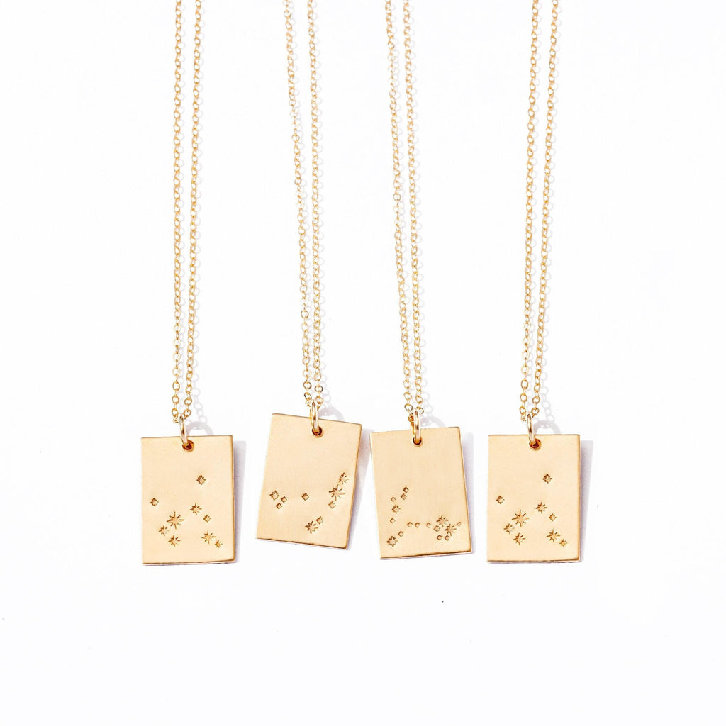 three gold necklaces with small stars on them