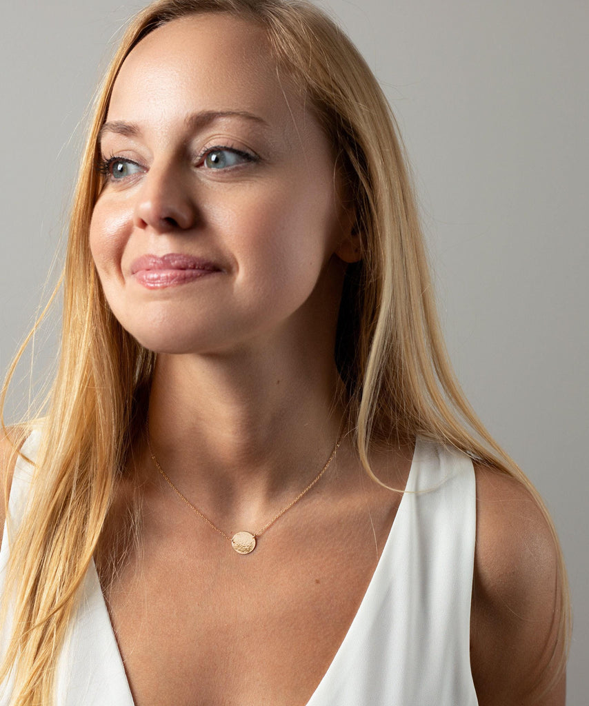 a woman in a white top is smiling