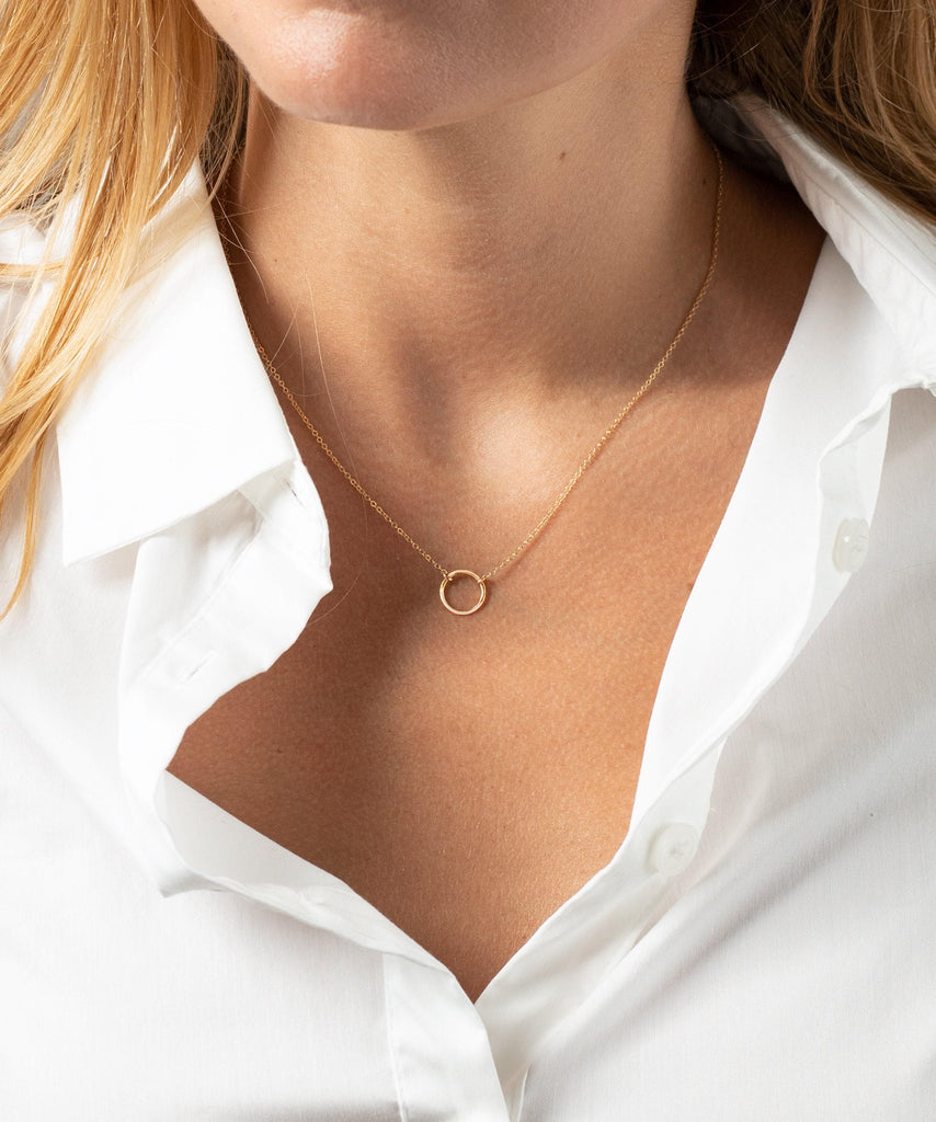 a woman wearing a white shirt and a gold necklace