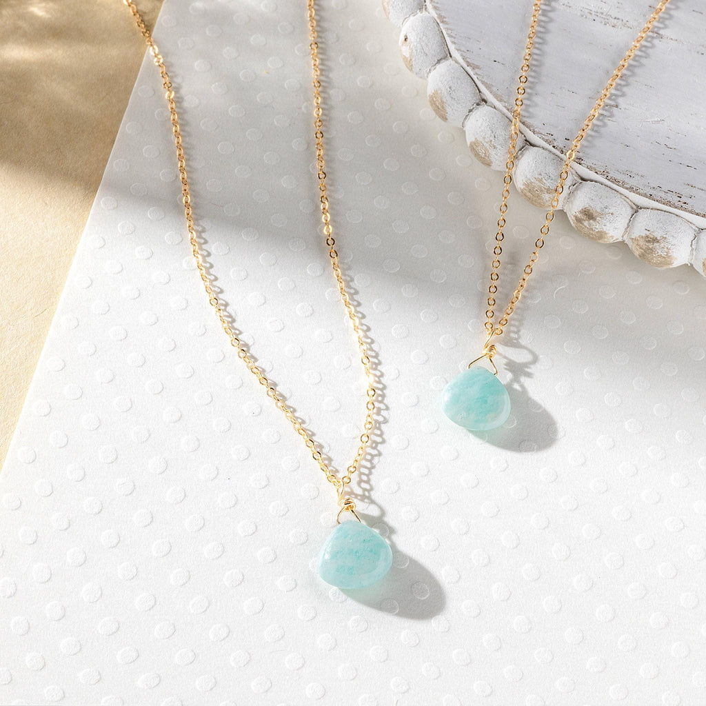 a close up of two necklaces on a table