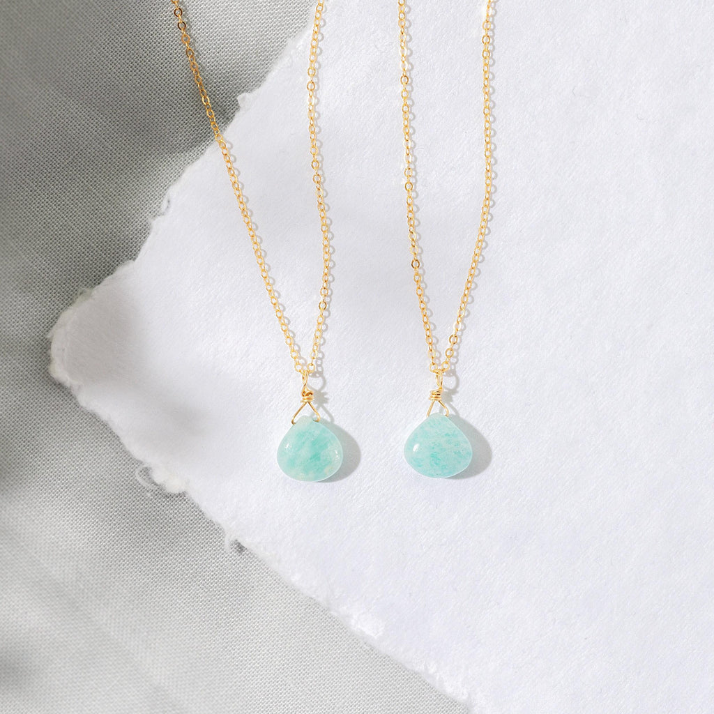 a pair of necklaces sitting on top of a piece of paper