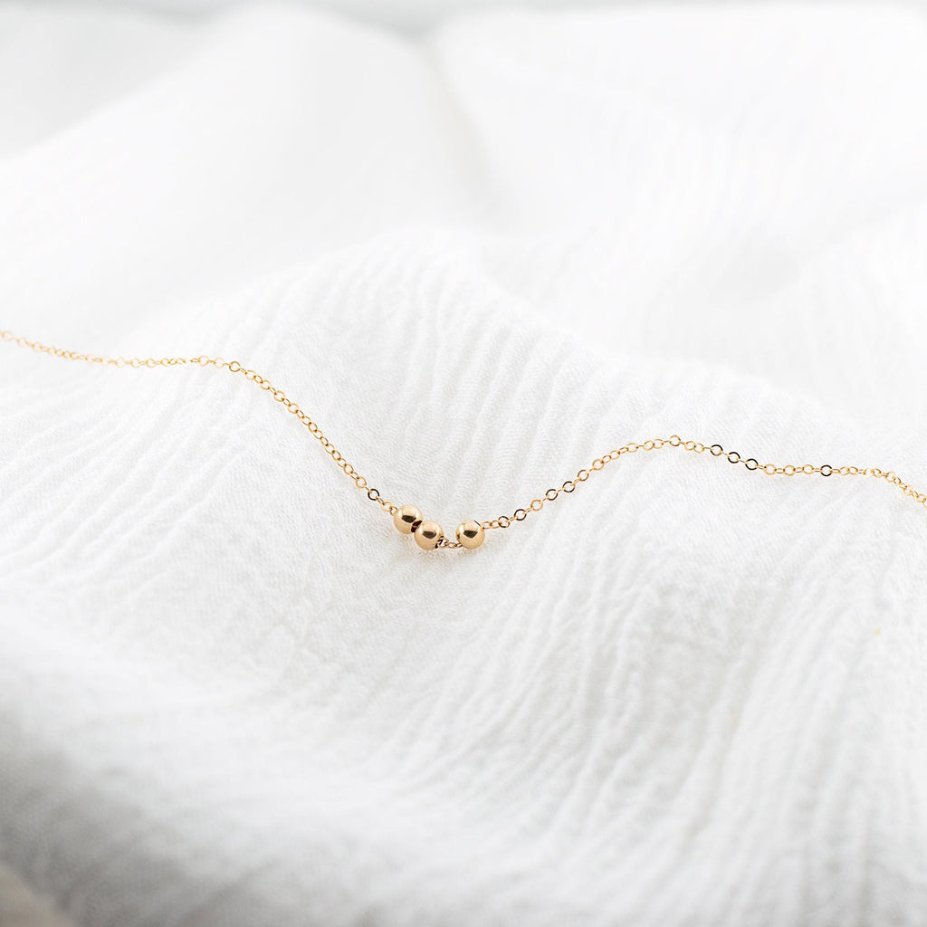 a close up of a gold necklace on a white blanket