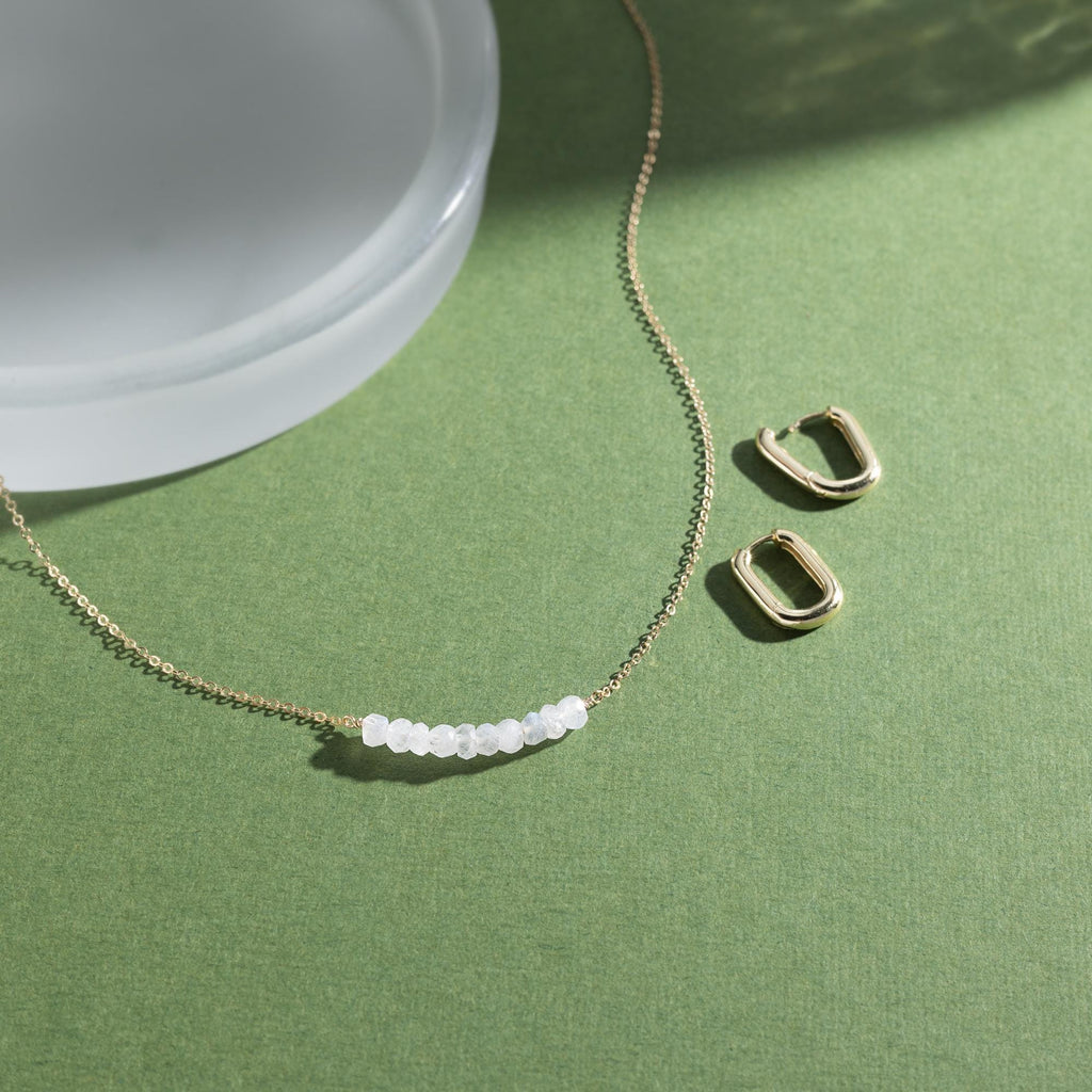 a necklace and earring sitting on a table