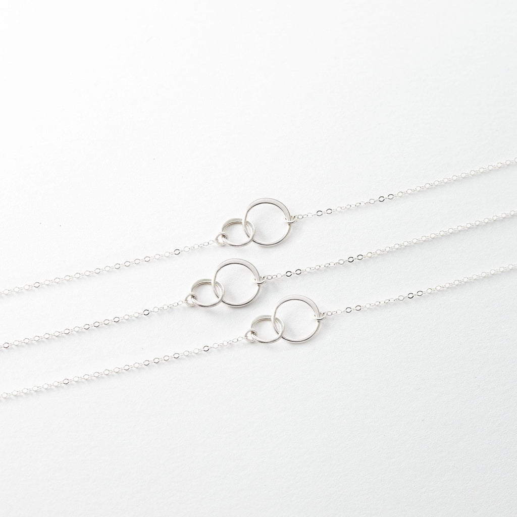 three silver necklaces on a white background