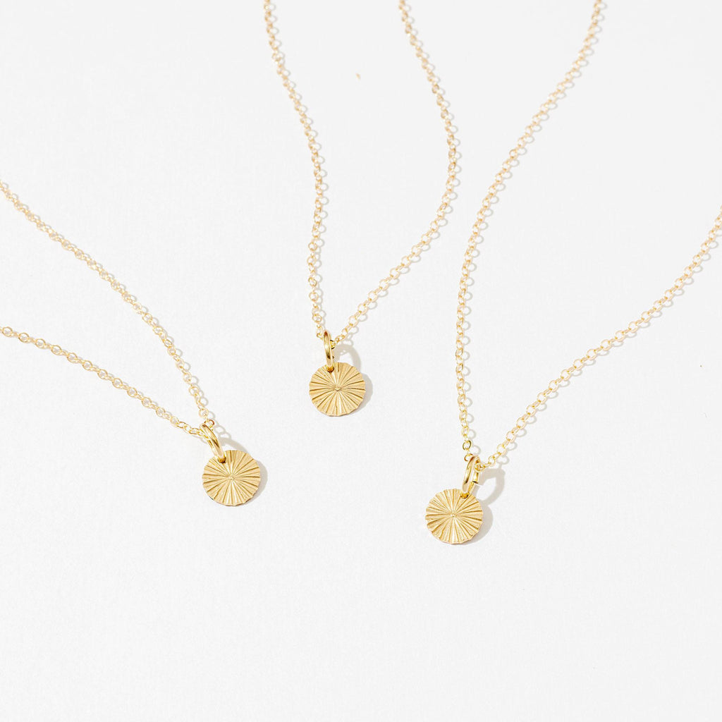 three necklaces with a shell on a white background