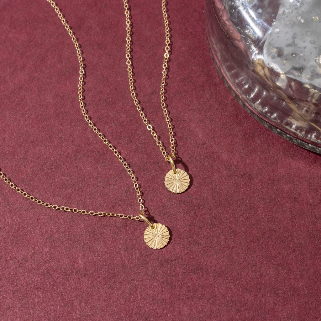 a close up of two necklaces on a table