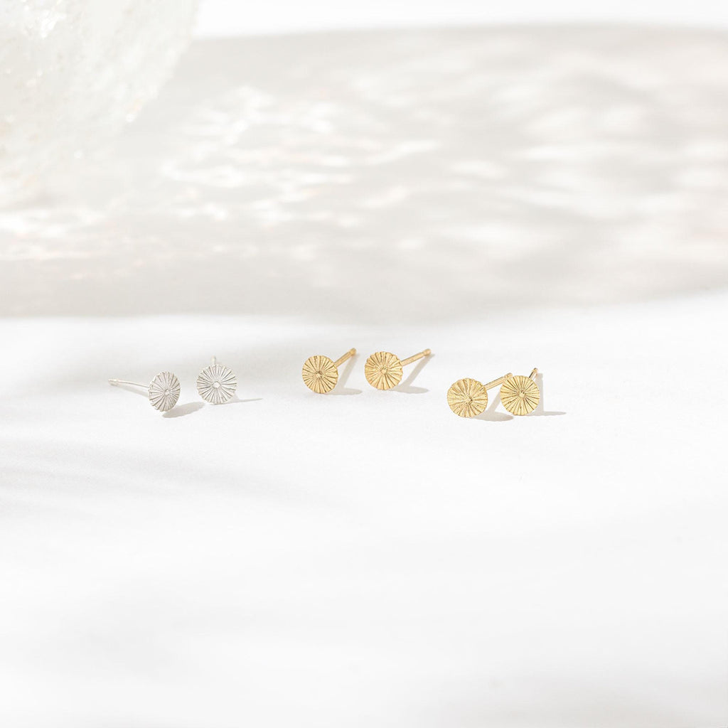 a pair of earrings sitting on top of a white surface