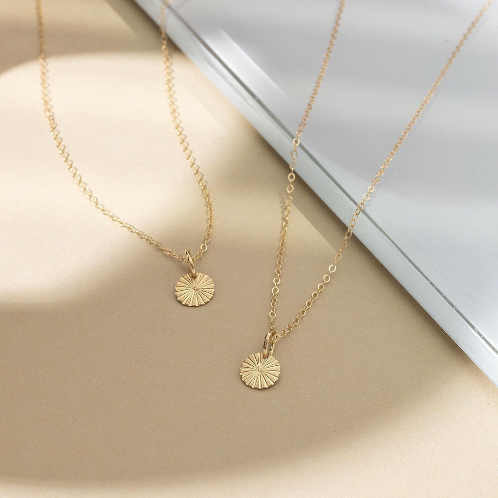 a close up of two necklaces on a table