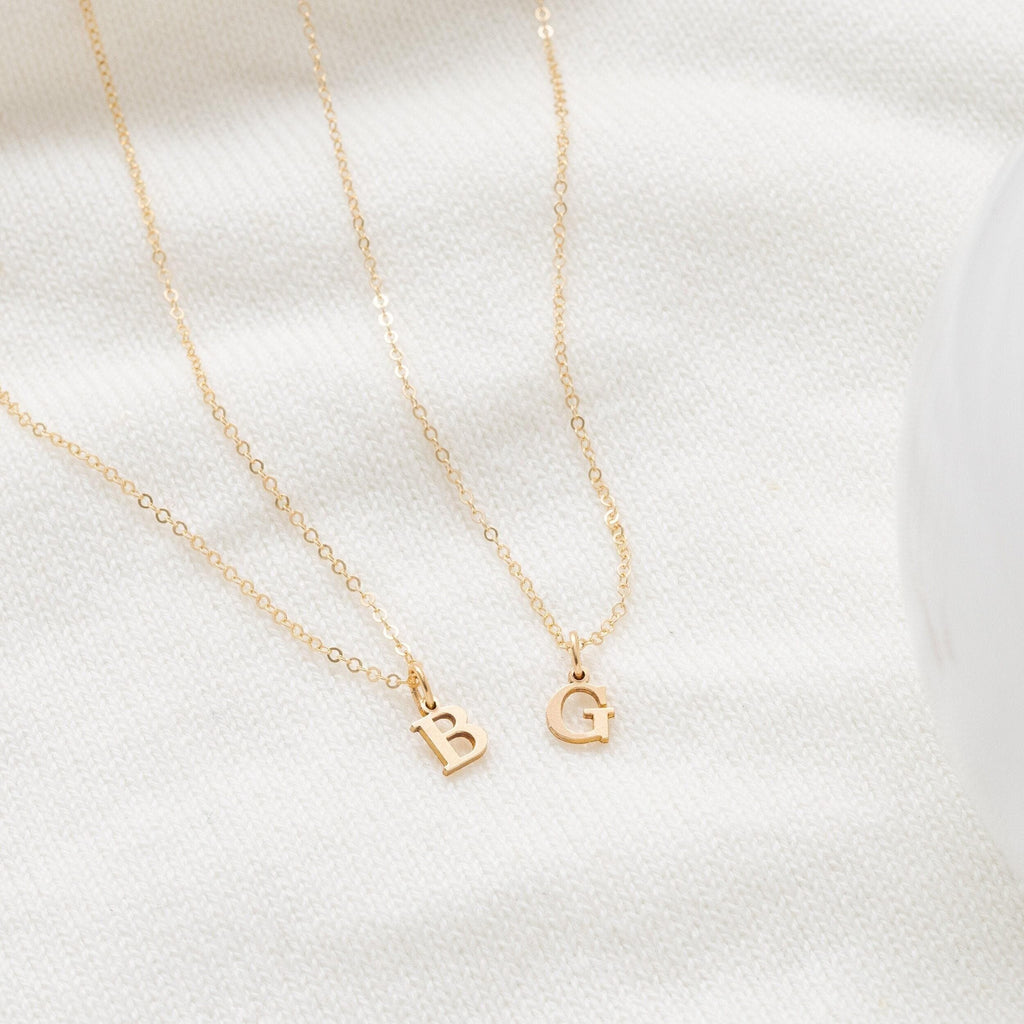 three different necklaces on a white surface