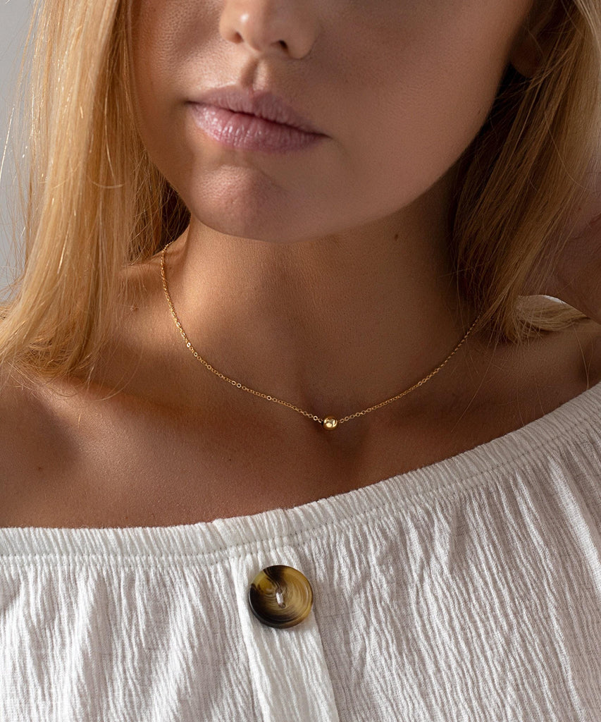 a close up of a woman wearing a necklace