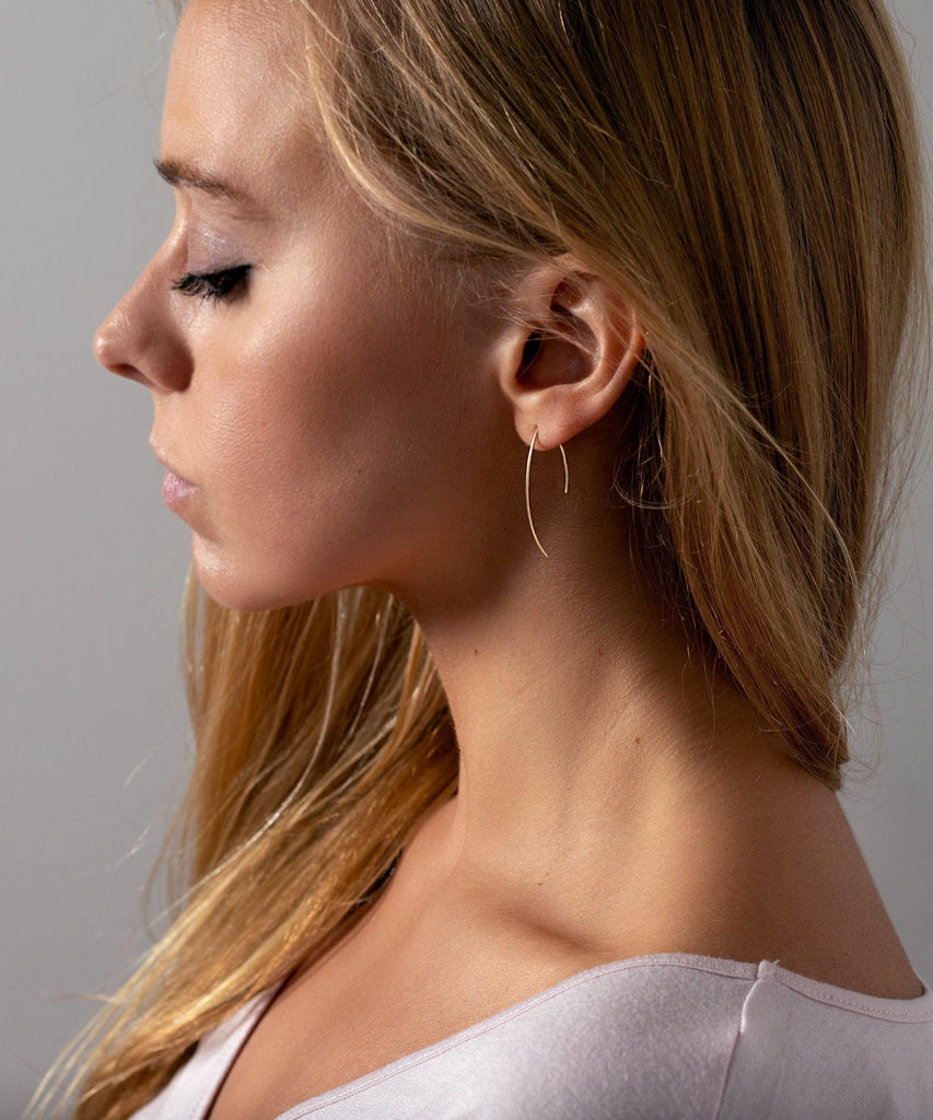 a close up of a person wearing a pair of earrings