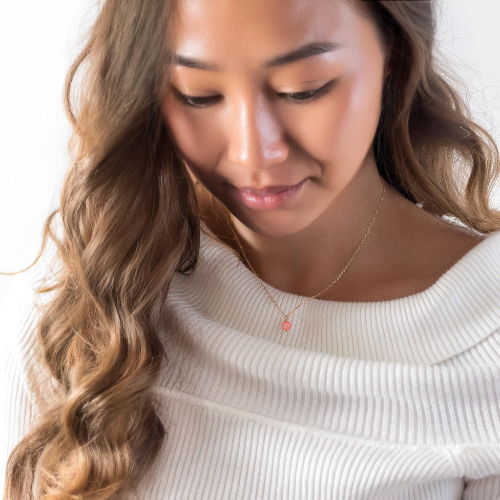 a woman wearing a white sweater holding a cell phone