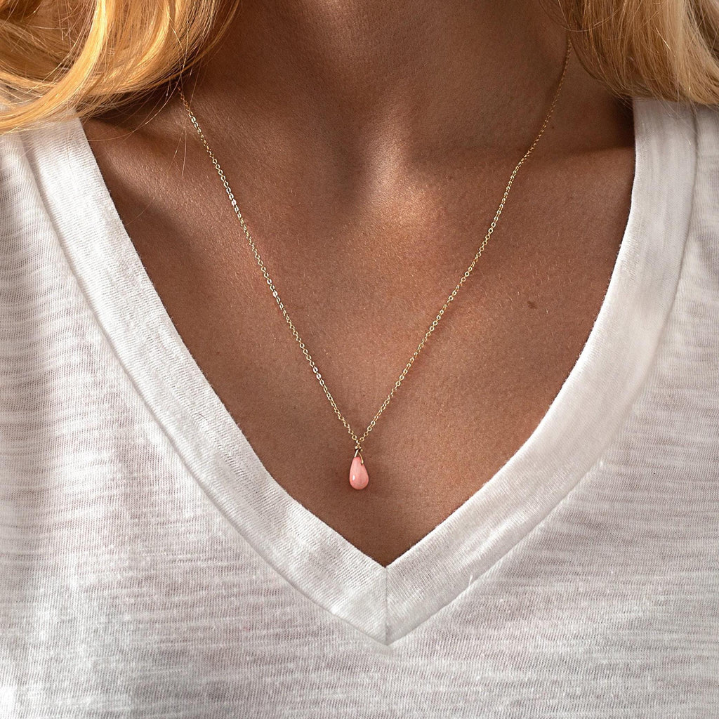 a close up of a woman wearing a necklace