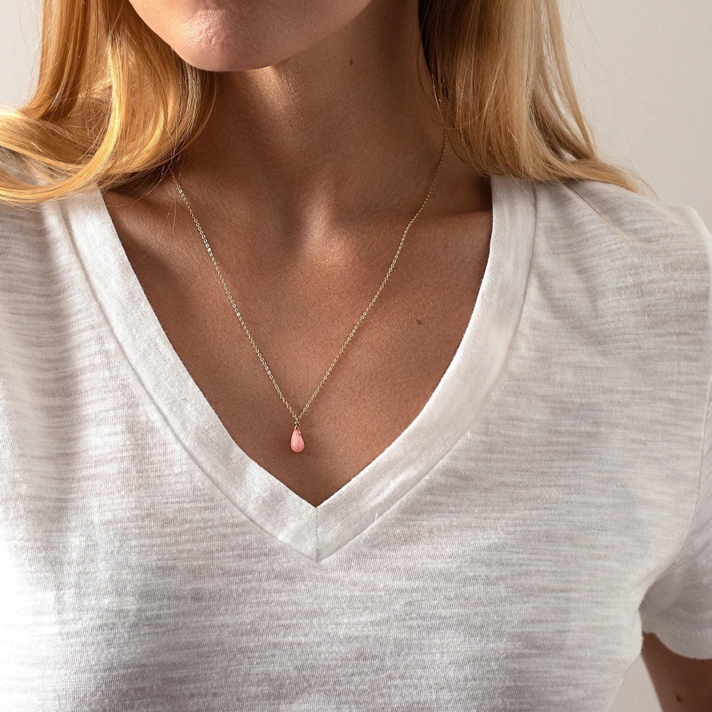 a woman in a white shirt is holding her stomach