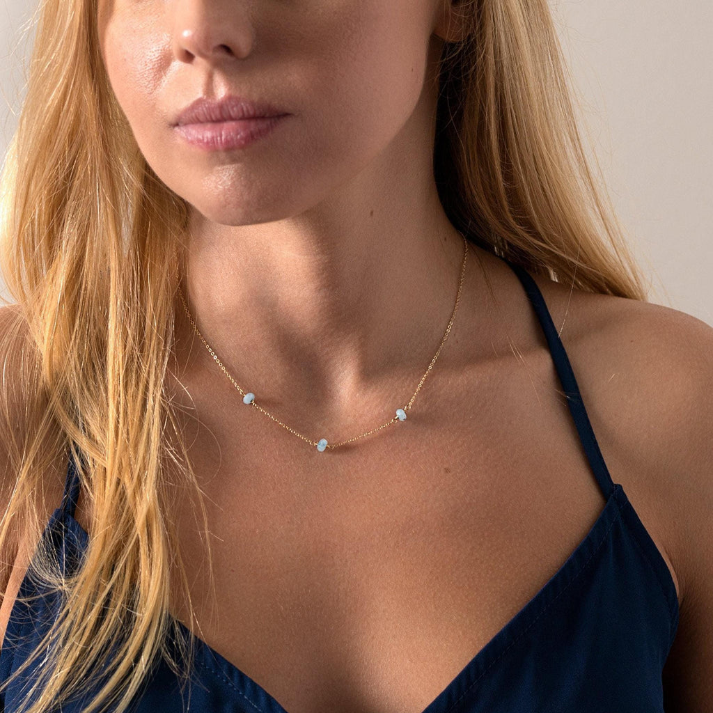 a woman wearing a blue top and a necklace