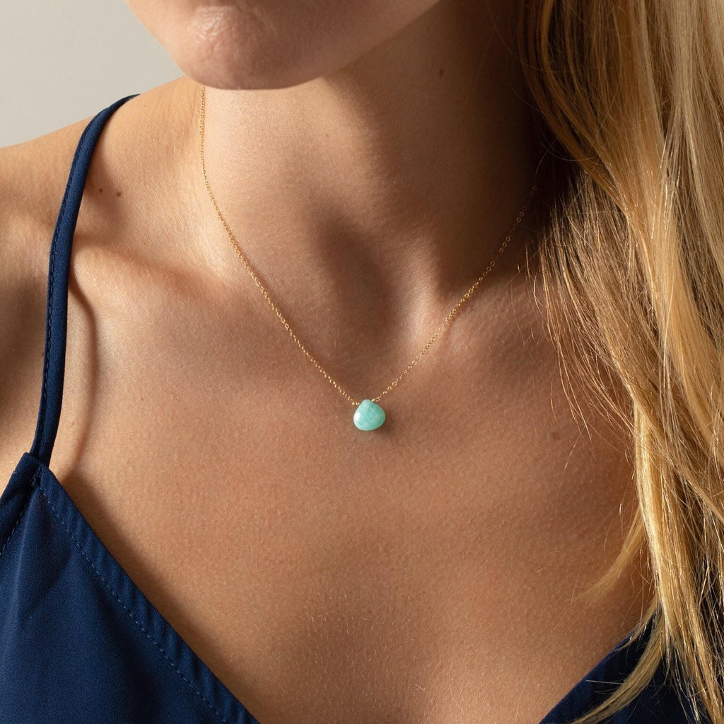 a close up of a woman wearing a necklace