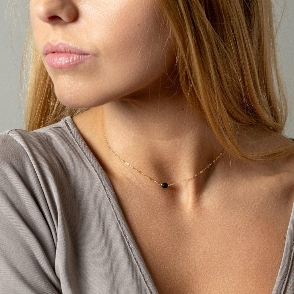 a close up of a woman wearing a necklace