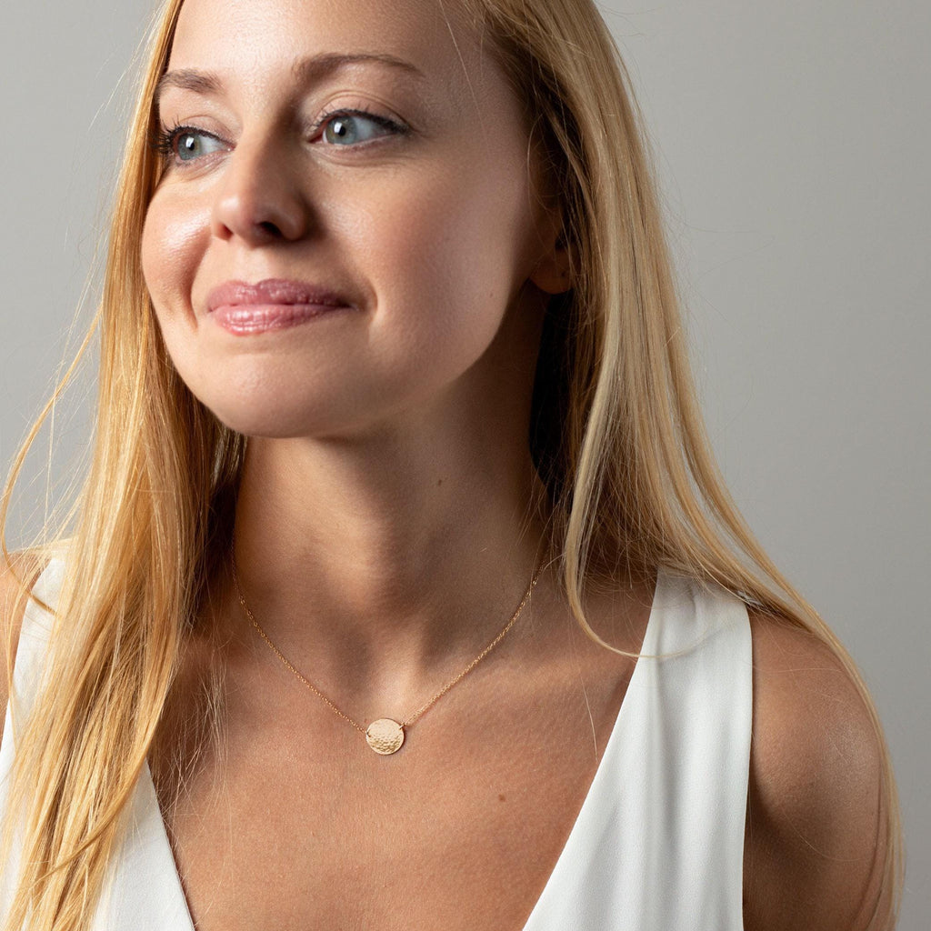 a woman in a white top is smiling